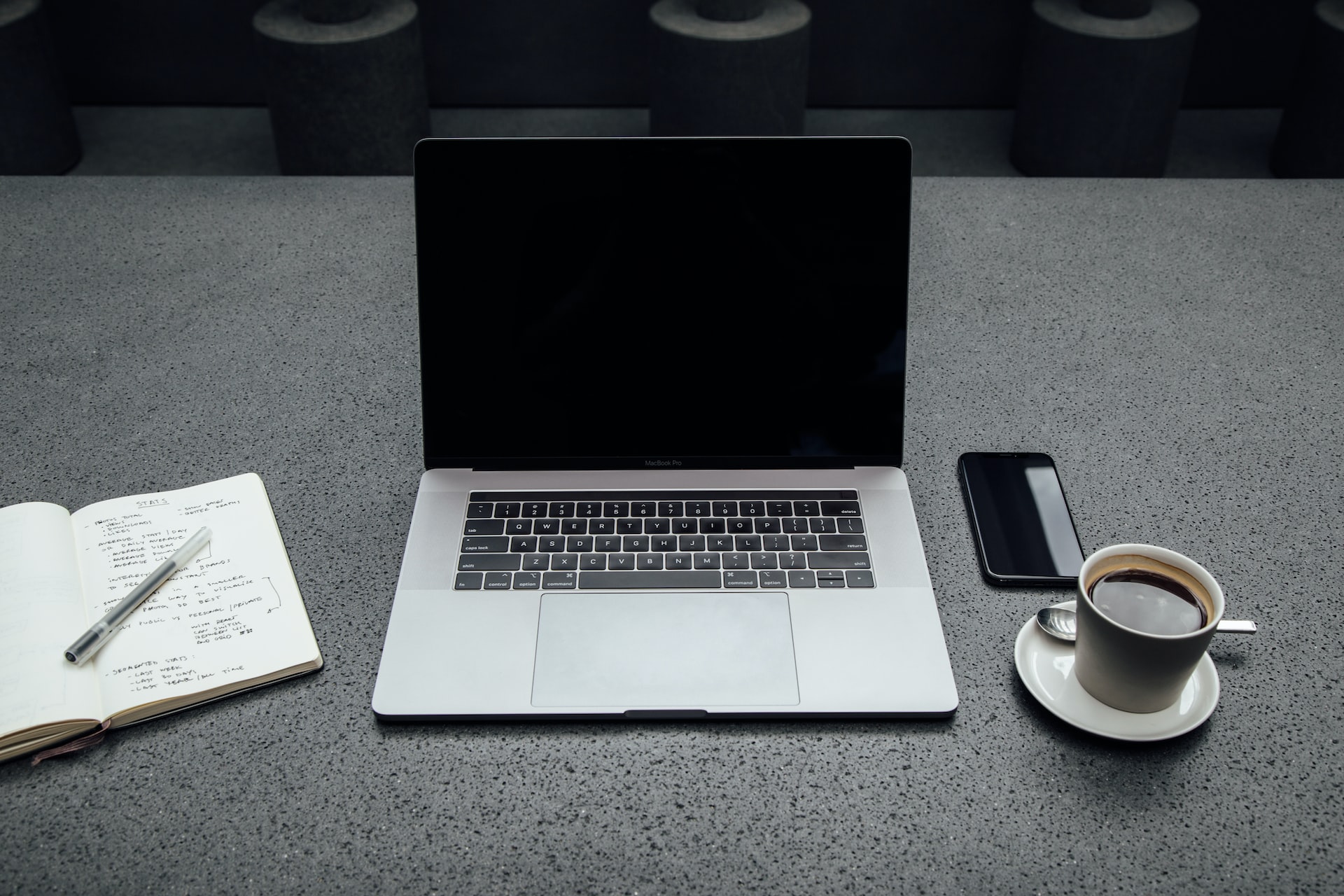Notebook, Kaffee und Notizblock auf Schreibtisch